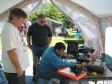 At the Candlewood Amateur Radio Association (CARA) Field Day, John tweaks out the last of the reflected power while Ken and Oscar look on.