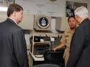 Gary Sessums, KC5QCN (left), Navy Captain Rick Low, N6CY (center) and John Grimes discuss communications capabilities at the new Pentagon MARS station. [Sally Sobsey, Department of Defense, Photo]